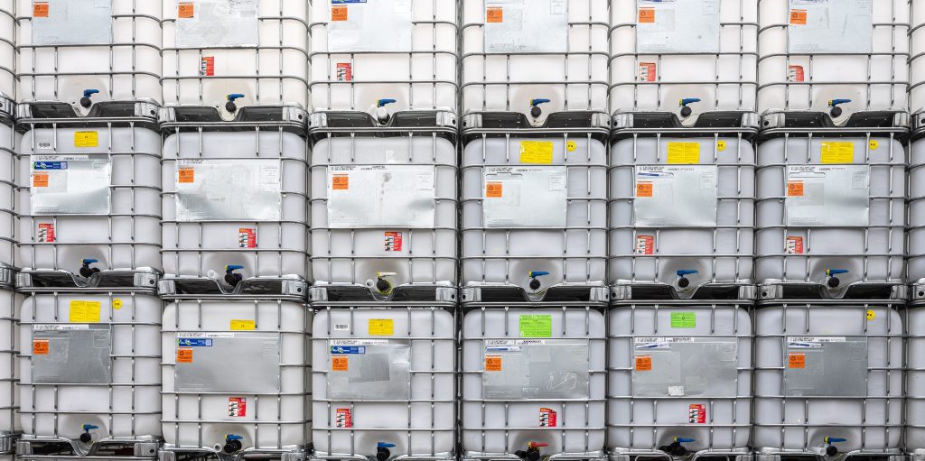 A row of IBC containers stacked securely in a warehouse, ready for transport or use