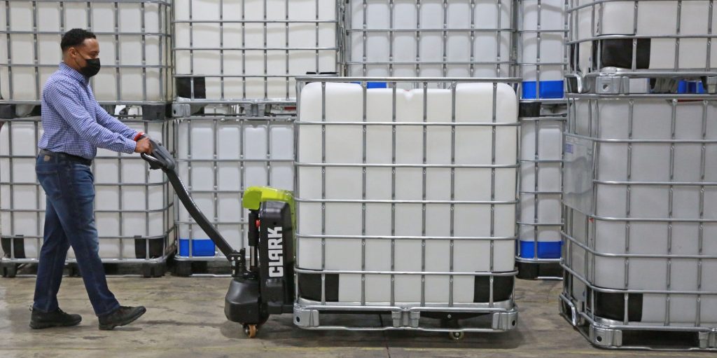 A 1,000-litre IBC container being transported on a pallet jack, demonstrating its capacity and portability.